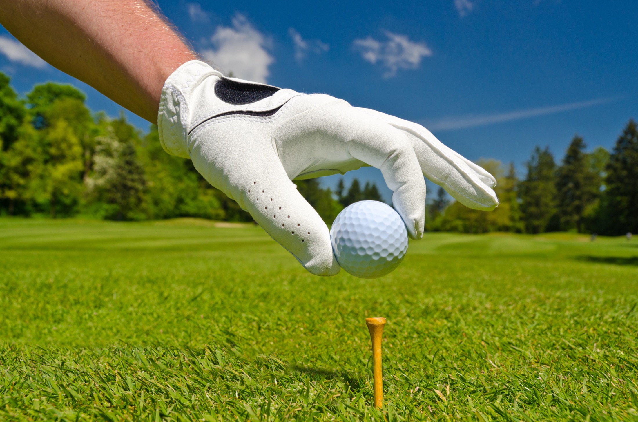 Golfer placing his ball atop his tee