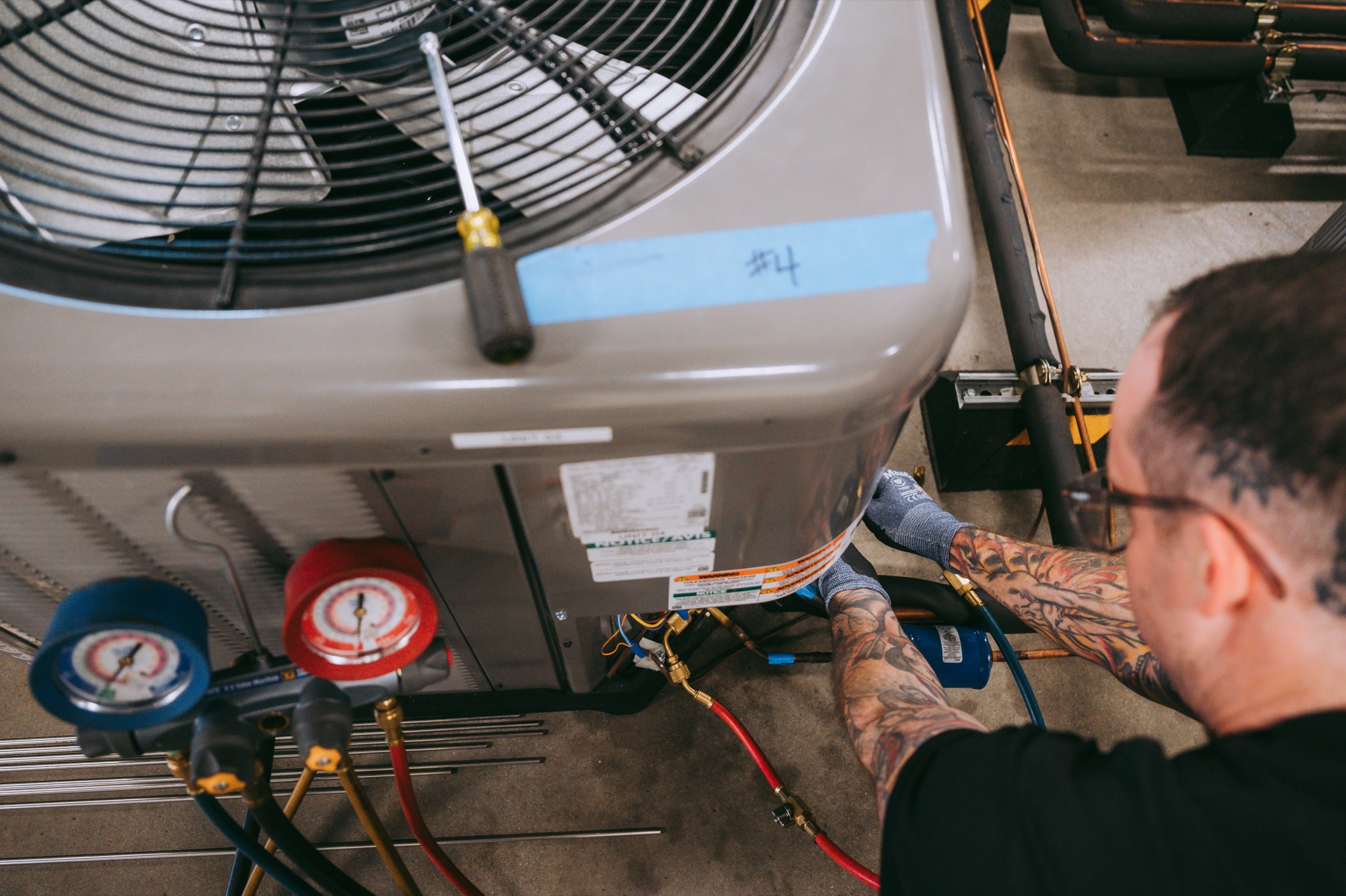 HVAC repairman working on a unit's pipes